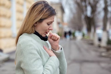 Hasta kız, kötü, hasta, öksüren sarışın genç bir kadın, Coronavirus tarafından vuruluyor, Covid2019 şehrin dışında duruyor..