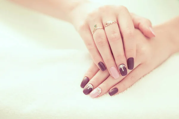 漂亮的米黄色 勃艮第红色的彩绘指甲油 手握宝石水晶石 指甲艺术修指甲的概念 — 图库照片
