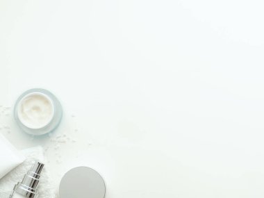 Organik kozmetik ürünleri. Etrafında tuz ve havlular olan şişeler. Telif alanı olan beyaz arka planda izole edilmiş. Düz yatış, üst görünüm.