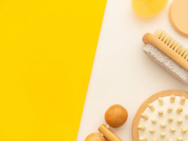 Spa sağlığı güzellik modeli, beyaz ve sarı arka planda çeşitli güzellik ürünlerinin düz yatağı, metin için boş fotokopi alanı. Kozmetik ve banyo aletleri SPA maketi