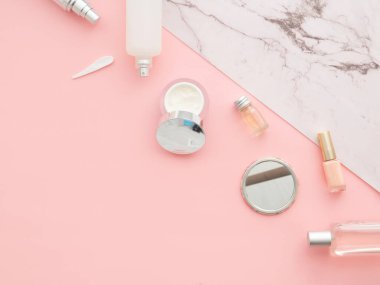 Tedavi edici yüz bakımı ürünleri pembe fotokopi alanı arka planı. Losyon pompası, parfüm, ayna, duş jeli, vücut yıkama, şampuan şişesi, krem