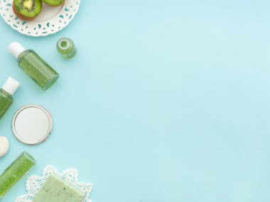 Doğal erkeksi kozmetik konsepti. Taze yeşil kivi yarımları, vücut duşu jeli sıvı el yapımı sabun aromalı meyvemsi aromalı kopya alanı olan mavi kağıt rengi arka plan. Düz üst görünüm