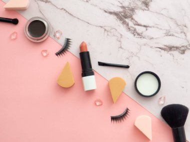 Kadın moda güzellik blogcusu çalışma alanı. Makyaj araçları, kozmetik ürünleri, iki renkli mermer ve pembe arka planda izole edilmiş, metin ya da ürünün için kopyalama alanı var. Üst manzara, düz uzanma