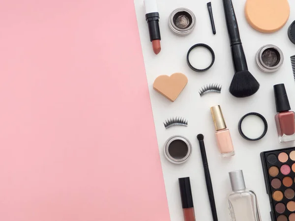 Female fashion beauty blogger workspace. Makeup tools cosmetics, lotion, nail polish, shower gel bottle, sponge, creams isolated on multicolored pink white paper copy space background. Top view