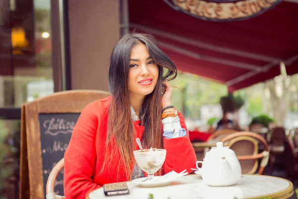 Indian girl at coffee shop. Outdoor portrait of a beautiful young girl smiling at a terrace balcony of a cafe.