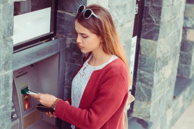 ATM 'de banka kartından para çeken bir kadın. Kız kredi kartını banka kasasında para çekmek için kullanıyor.