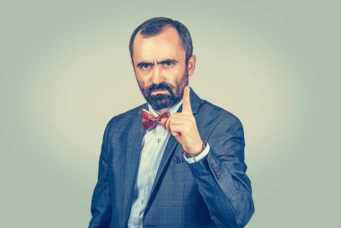 Yakın plan portre portresi. Kendine güveni tam, ciddi bir genç adam. İşadamı, izole edilmiş açık yeşil arka planı hatırlatmak için işaret parmağını gösteriyor. Çok kültürlü etnik melez Latin Kafkas modeli