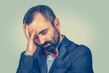 Kederli adamın portresi, açık yeşil arka planda izole edilmiş, sarı gradyan ile aşağıya bakıyor.