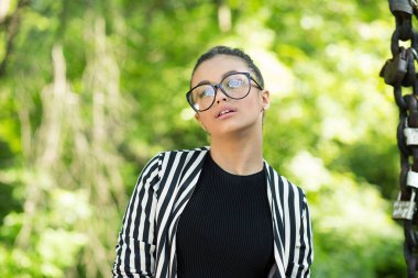 Ben seksiyim ve bunu biliyorum. Yakın plan portresi güzel esmer kadın kilitleri olan bir zincirin yanındaki yeşil doğa arka plan duvarında izole görünüyor. Pozitif duygu yüz ifadesi