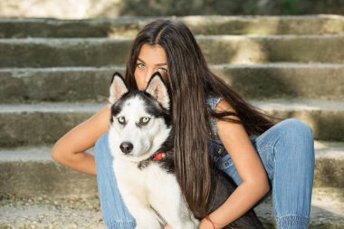 Güzel kadın ve evcil hayvanı. İri köpekli zayıf kız arka plandaki beton gri merdivenleri izole etti. İkisi de merdivenlerde kameraya bakıyor. Köpeği dışarı çıkarıyorum. Erkeklerin en iyi kadın arkadaş konsepti
