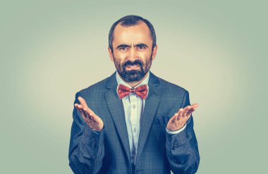 Kızgın genç iş adamı hayal kırıklığı içinde ellerini havaya kaldırarak sana kızgın bir şekilde bakıyor. Gri arka planda izole edilmiş melez sakallı bir model ve fotokopi alanı. Yatay resim