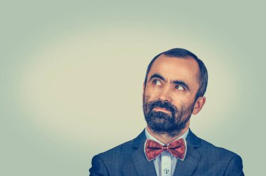 Stüdyoda sola bakan bir adam var. Yeşil sarı eğimli arka planda izole edilmiş melez sakallı model. Pozitif duygu