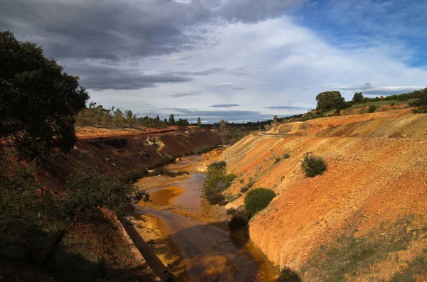 Rio poluído por enxofre e ferro entre os campos de cascalho e escoria — Fotografia de Stock