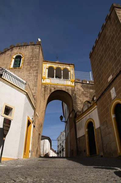 サンタ クララ アーチウェイは 石畳の通りの上にあり 石造りの建物に囲まれています 青い空だ ポルトガルのエルヴァス町 — ストック写真