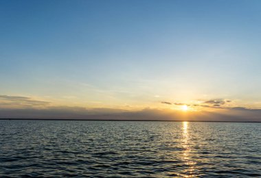 Deniz, altın, koyu mavi gökyüzü üzerinde güzel gün batımı