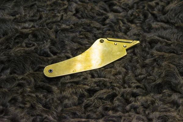 Furrier's knife on karakul lambskin texture background — Stock Photo, Image