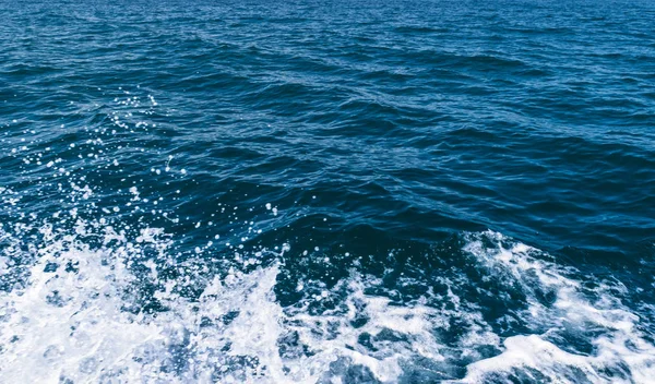 Vizet, fröccsen az óceán napsütésben, közelről — Stock Fotó