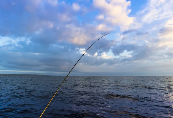 Fishermans spinnspö i sol och blå himmel — Stockfoto