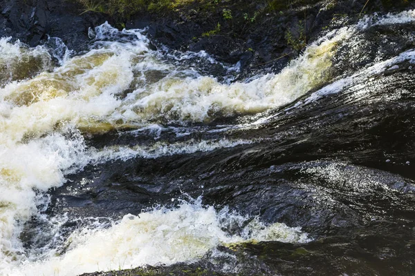 Fechar cachoeira entre rochas em um dia ensolarado, fluxo tempestuoso — Fotografia de Stock