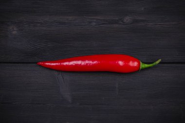Koyu ahşap arka plan üzerinde kırmızı biber biber