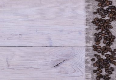 Kahve çekirdekleri beyaz tahta ve çuval bezi doku arka plan