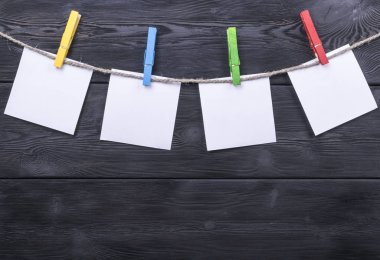 Boş fotoğraf kağıtları ile ahşap arka plan doku üzerinde asılı clothespin