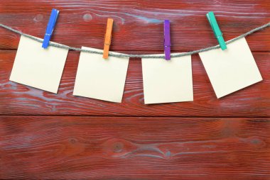 Boş fotoğraf kağıtları ile ahşap arka plan doku üzerinde asılı clothespin