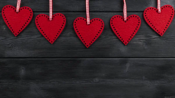 Röda hjärtan på svart rustikt trä bakgrund med woodgrain konsistens — Stockfoto
