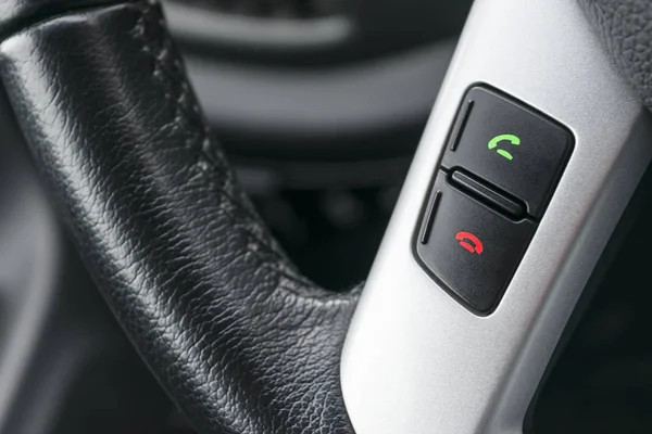 Hands free and media control buttons on the steering wheel in black leather, modern car interior — Stock Photo, Image