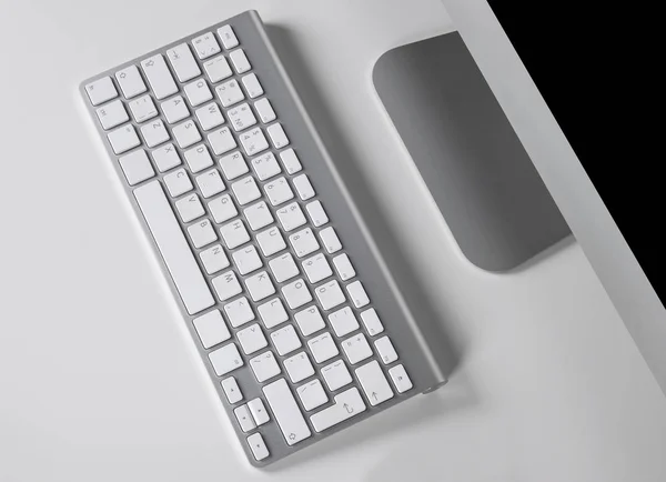Рабочее место с компьютером и беспроводной клавиатурой на белом фоне — стоковое фото