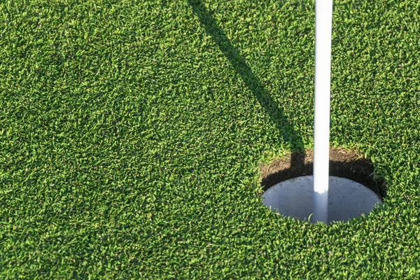 Buraco de golfe na grama verde do campo de golfe. Vista do buraco de golfe no campo verde . — Fotografia de Stock