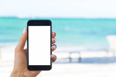 Güzel kadın eli beach adlı akıllı telefon kullanarak. Smartphone beyaz ekran. Boş boş ekran