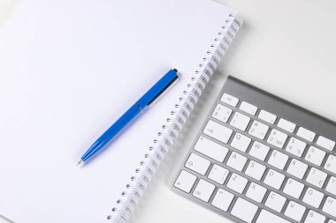 Kablosuz bilgisayar klavye, defter ve kalem iş Ofis Masası üzerinde