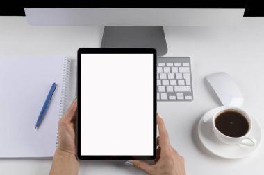 Tablet bilgisayar ile izole perde ve kahve holding kadın eller. İş çalışma alanı ile bilgisayar ve kablosuz fare ve keyboard.business nesneleri