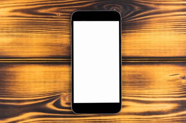 Cep telefonu ile boş perde kadar sahte yanık ahşap masa arka plan üzerinde izole. Ahşap masa üstünde smartphone. Smartfone beyaz