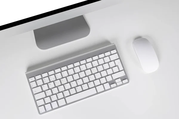 Local de trabalho com computador e teclado e mouse sem fio no fundo branco — Fotografia de Stock