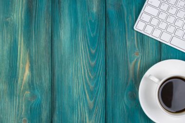 Ofis Masası kopya alanı ile. Dijital cihazlar kablosuz klavye ve fare kahve, üstten görünüm mavi ahşap tablo