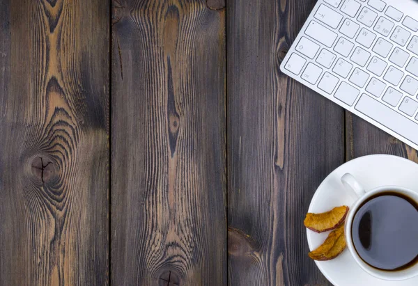 Escritorio de oficina con espacio para copias. Dispositivos digitales teclado inalámbrico y ratón en la mesa de madera oscura con taza de café, vista superior — Foto de Stock