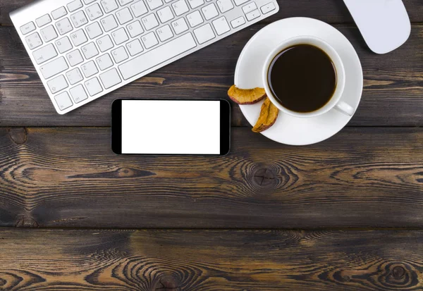 Escritorio de oficina con espacio para copias. Dispositivos digitales teclado inalámbrico, ratón y smartphone con pantalla vacía en mesa de madera oscura con taza de café, vista superior — Foto de Stock