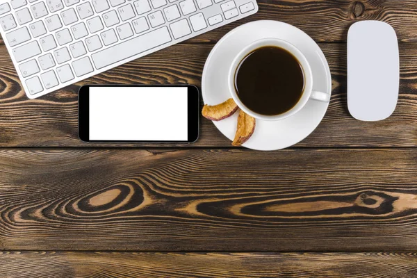 Escritorio de oficina con espacio para copias. Dispositivos digitales teclado inalámbrico, ratón y smartphone con pantalla vacía en mesa de madera oscura con taza de café, vista superior — Foto de Stock
