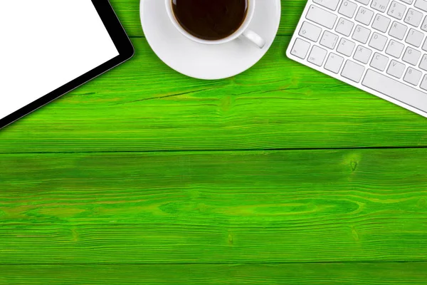 Escritorio de oficina con espacio para copias. Dispositivos digitales teclado inalámbrico, ratón y tableta con pantalla vacía en la mesa de madera verde con taza de café, vista superior — Foto de Stock
