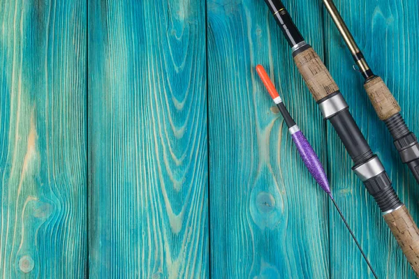 Aparejos de pesca - flotador de pesca de caña y señuelos sobre hermoso fondo de madera azul —  Fotos de Stock