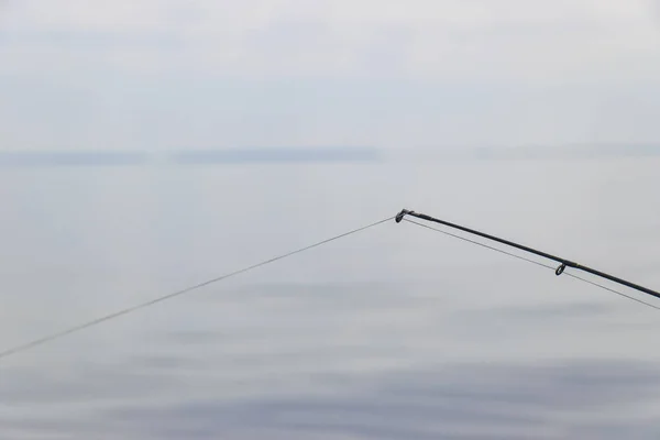 美しい曇りの海の上の行でボート釣りロッド — ストック写真