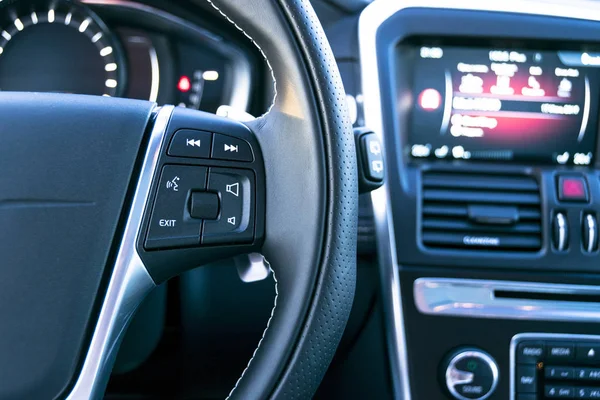 Media bedieningsknoppen op het stuurwiel in zwart leer met computermonitor, moderne auto-interieur — Stockfoto