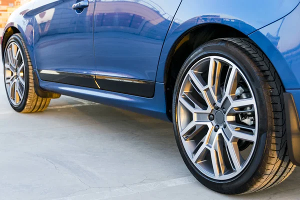 Шиномонтажне колесо сучасного блакитного автомобіля на землі, зовнішні деталі автомобіля — стокове фото