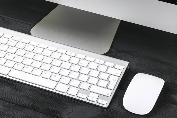 Lugar de trabajo empresarial con ordenador, teclado inalámbrico y ratón sobre fondo de mesa de madera negro. Escritorio de oficina con espacio de copia — Foto de Stock