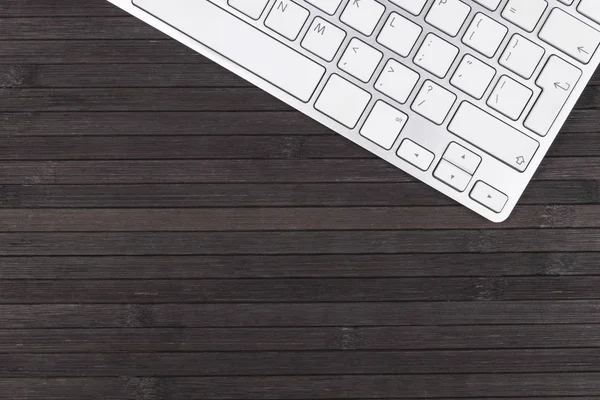 Vista de cerca de un lugar de trabajo de negocios con teclado de computadora inalámbrica, ratón y teclas en el fondo de mesa de madera negro viejo. Escritorio de oficina con espacio de copia — Foto de Stock