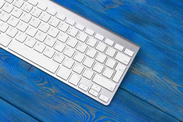 Lugar de trabajo de negocios con teclado inalámbrico sobre fondo de mesa de madera azul antiguo. Escritorio de oficina con espacio de copia — Foto de Stock