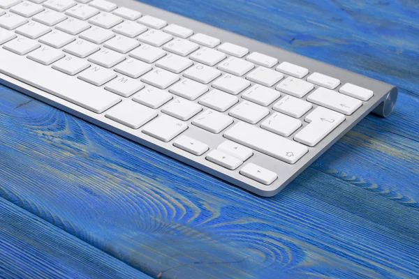 Lugar de trabajo de negocios con teclado inalámbrico sobre fondo de mesa de madera azul antiguo. Escritorio de oficina con espacio de copia — Foto de Stock