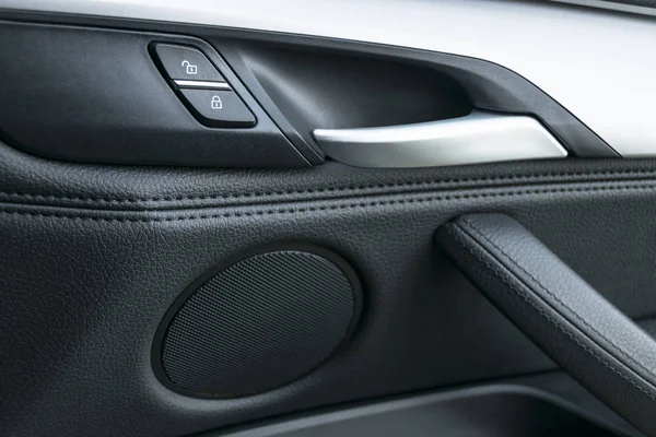 Deurklink van de auto in de luxe moderne auto met zwart leder en schakelaar knopbesturingselement, moderne auto interieur details — Stockfoto